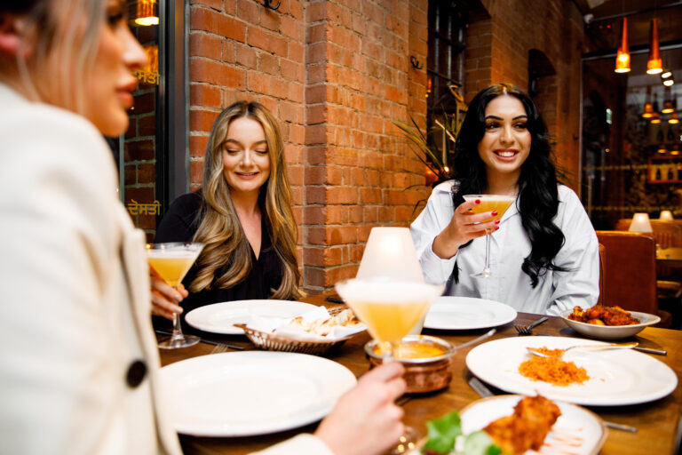 Spice up your winter festivities with Rasoi Indian Kitchen. Group of women enjoying an Indian meal and cocktail drinks at award winning Rasoi